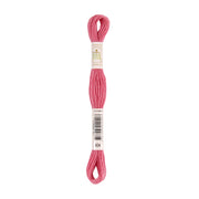 Ein Knäuel rosa Stickgarn, um dessen Mitte ein Etikett gewickelt ist.