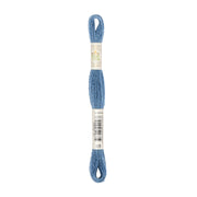 Ein Knäuel blaues Stickgarn, um dessen Mitte Produktetiketten gewickelt sind – dieses naturfarbene Stickgarn besteht aus natürlich gefärbtem Garn und eignet sich für farbenfrohe und umweltfreundliche Stickprojekte.