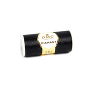 Eine Spule DMC Diamant schwarzes Metallic-Stickgarn mit goldenem und weißem Etikett, perfekt, um jedem Stickprojekt einen schimmernden Metalleffekt zu verleihen.
