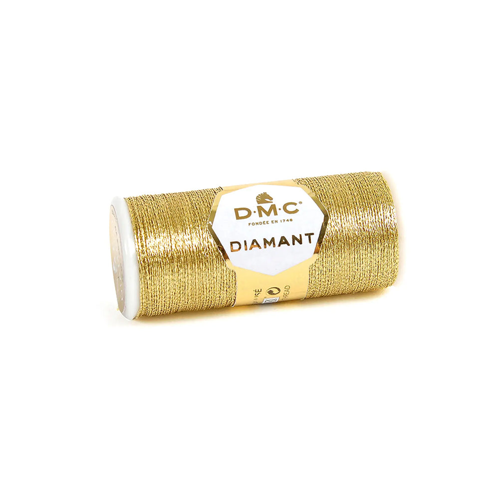 Eine Spule DMC Diamant Garn in Goldmetallic ruht auf einem weißen Hintergrund, ideal für schimmernde Stickereien.