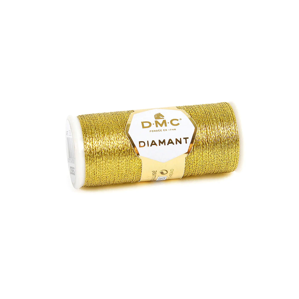 Eine Spule DMC Diamant Metallic Gold Stickgarn auf weißem Hintergrund.