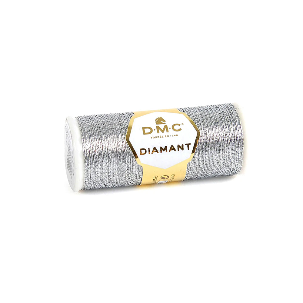 Eine Spule DMC Diamant Garn, ein silbernes, metallisch glänzendes Stickgarn der Marke DMC, liegt auf weißem Hintergrund.