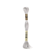 Ein Strang hellgrauer DMC Mouliné Garn Stickgarn aus 100% Baumwolle mit einem schwarz-goldenen Etikett auf weißem Grund.