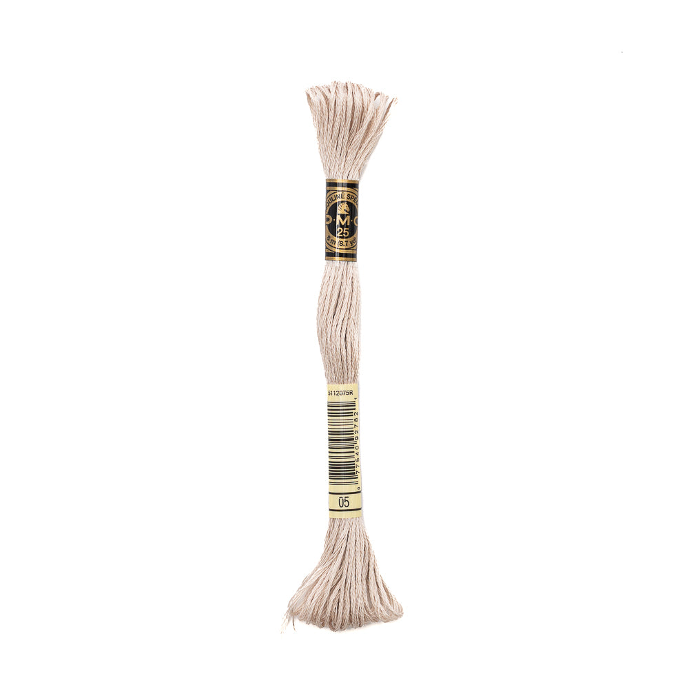 Ein Knäuel beigefarbenes DMC Stickgarn aus 100% Baumwolle mit einem schwarz-goldenen Etikett, isoliert auf weißem Hintergrund.
