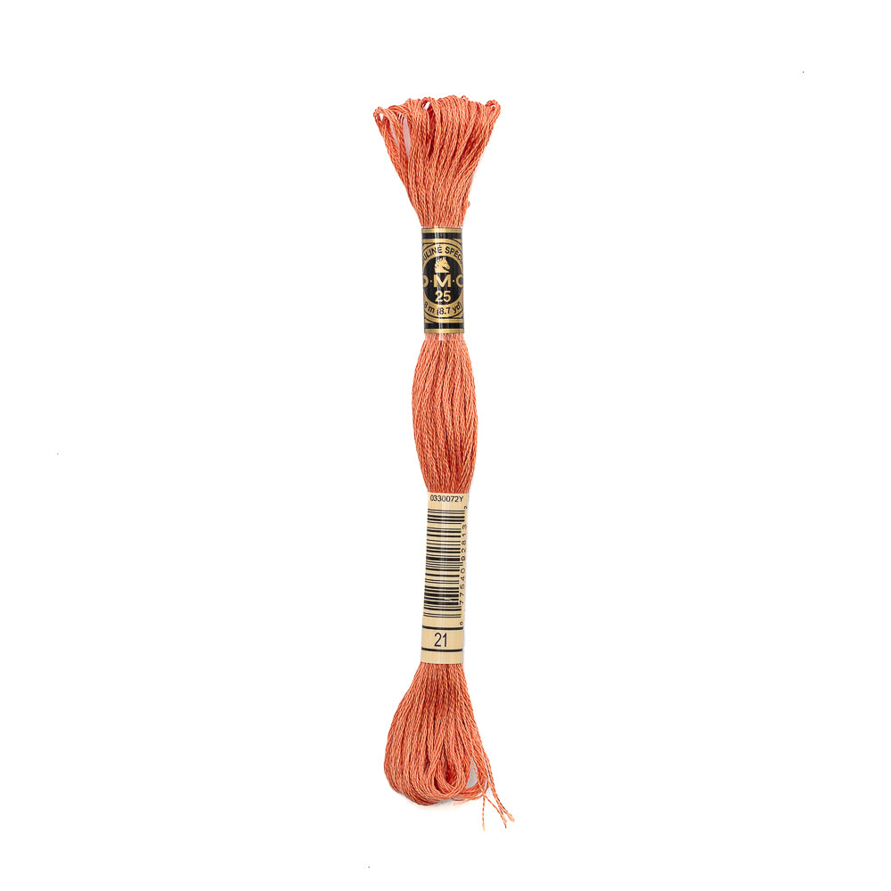 Ein Strang korallenfarbener DMC Mouliné Garn Stickgarn, 100% Baumwolle, mit einem schwarz-goldenen Etikett ruht auf einem weißen Hintergrund. Dieses teilbare Stickgarn ist ideal für detaillierte Stickprojekte.
