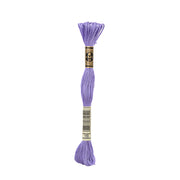 Ein Strang DMC-Stickgarn, Farbe 155 (Lavendel), ist mit einem schwarz-goldenen Etikett mit der Nummer 155 auf dem Boden versehen.