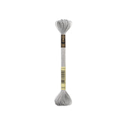 Ein Strang silbernes Effektgarn von DMC mit einem schwarz-goldenen Etikett, perfekt, um Ihren Stickprojekten metallischen Glanz zu verleihen.