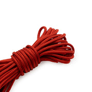 Ein aufgerolltes Bündel aus leuchtend roter Nylon-Flechtkordel der Marke ☆ auf weißem Hintergrund.