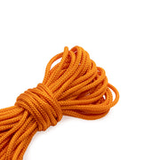 Eine Rolle ☆ leuchtend orangefarbenes Nylonseil, ordentlich aufgerollt vor einem weißen Hintergrund.