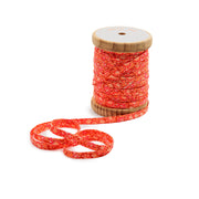 Eine Rolle mit rotem Blumenband, ideal für Nähprojekte, wobei ein Teil des Bandes abgewickelt und auf einem weißen Hintergrund zu einer Schleife gebunden ist.
