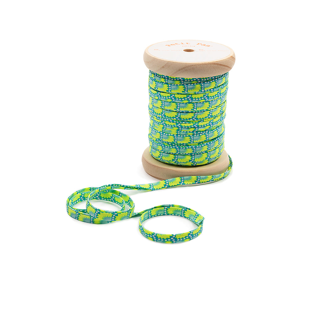 Eine Rolle Band mit einem geometrischen Muster in Blau, Gelb und Grün – ideal als Schrägband für Nähprojekte – auf einem schlichten weißen Hintergrund.