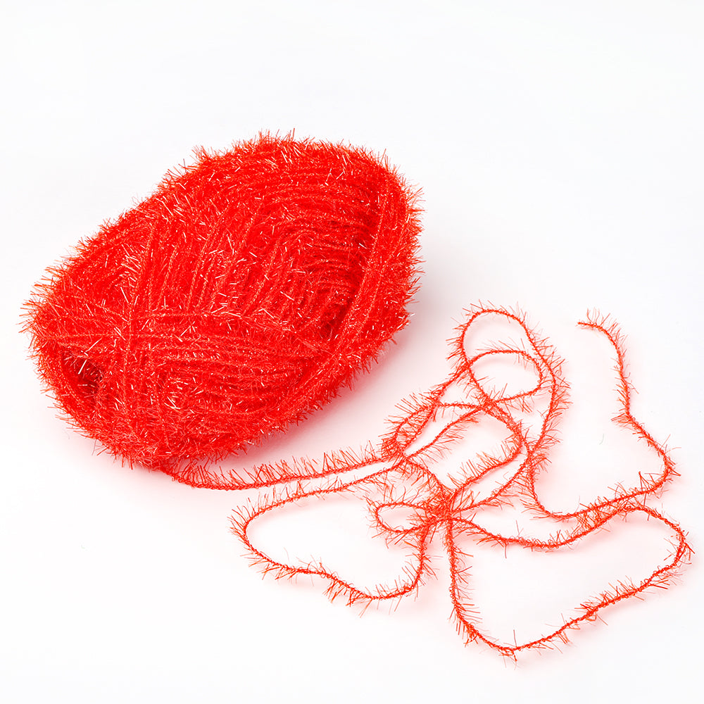 Ein Knäuel leuchtend rotes, flauschiges Rico Design Garn aus robustem Garn mit einigen losen Strängen auf weißem Grund.