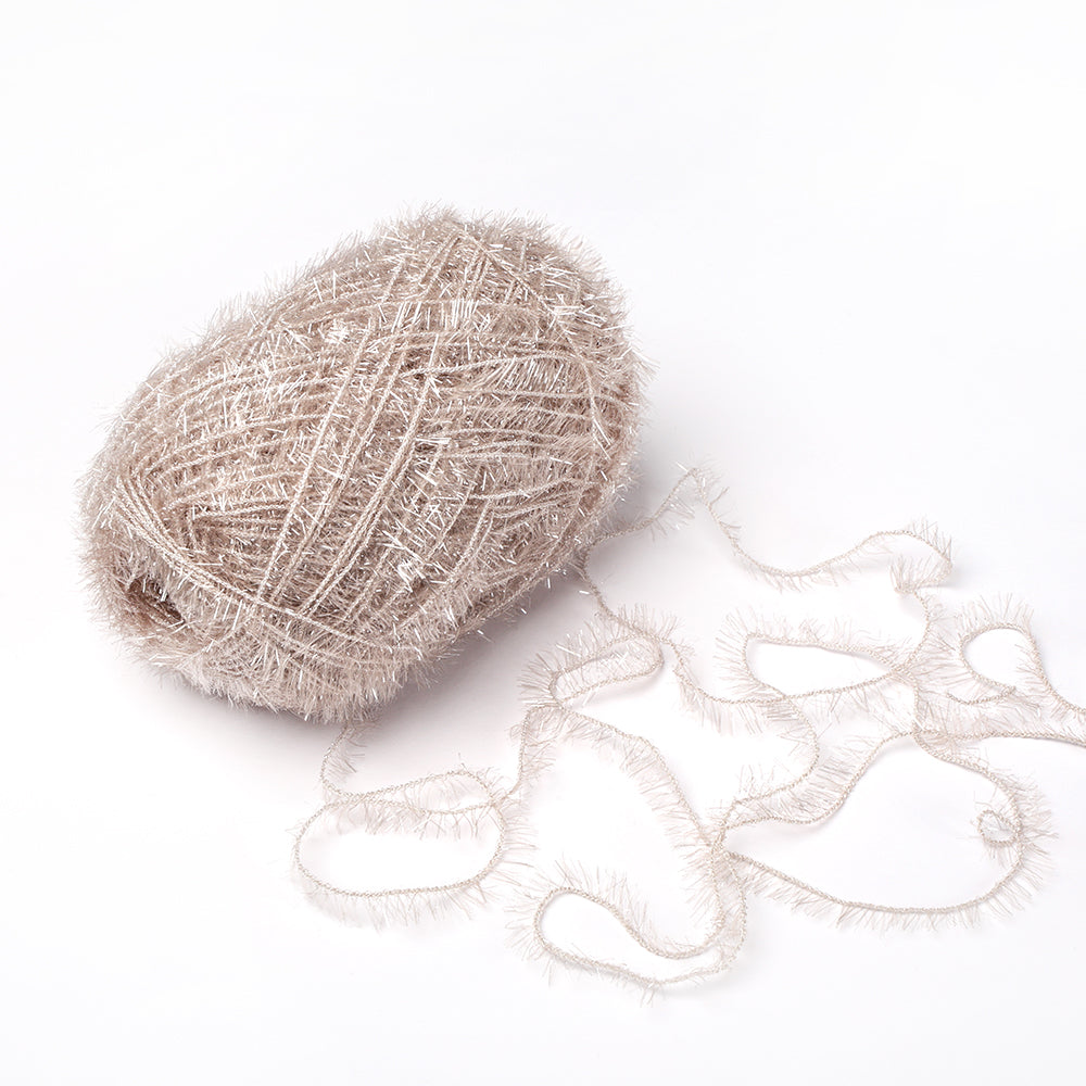 Ein Knäuel aus strukturiertem, beigem Rico Design robustes Garn mit einem losen Strang auf weißem Grund - perfekt für Häkelprojekte wie Häkeln Spüllappen.