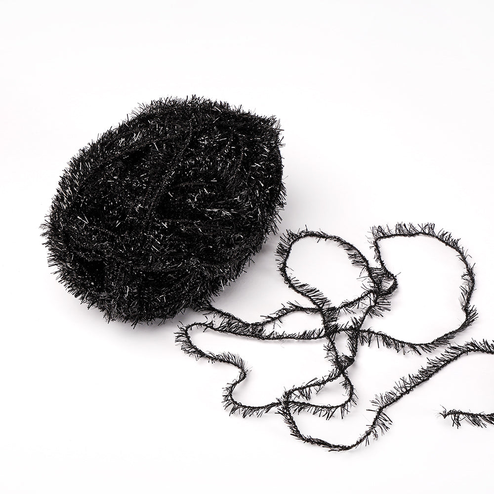 Ein Knäuel aus schwarzem, glitzerndem Rico Design Creative Bubble Garn mit einem losen Strang liegt auf weißem Grund - ideal zum Häkeln von Geschirrtüchern und anderen kreativen Projekten.