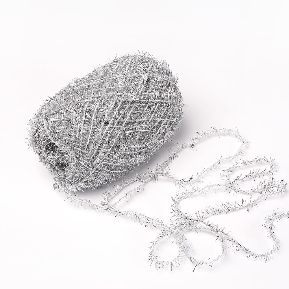 Ein Knäuel silberglänzendes Rico Design Creative Bubble Garn mit einem losen Strang auf weißem Grund - ideal zum Häkeln oder für einzigartige Schrubber.