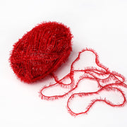 Ein Knäuel rotes Rico Design Creative Bubble Garn mit einer losen Strähne auf weißem Hintergrund.