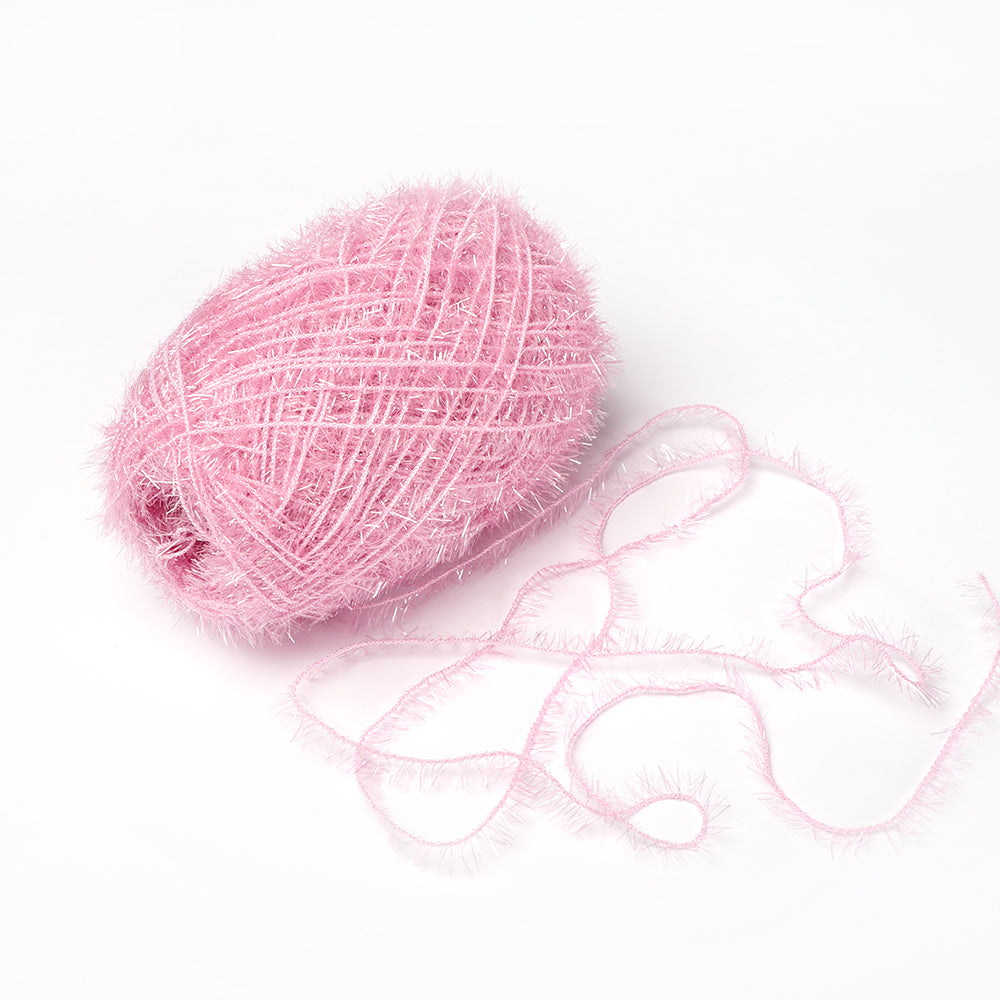 Ein Knäuel rosa, flauschiges Rico Design Creative Bubble Garn mit einem losen Strang ruht auf einem weißen Hintergrund - ideal für Häkeln Spüllappen oder jedes Projekt, das robustes Garn benötigt.