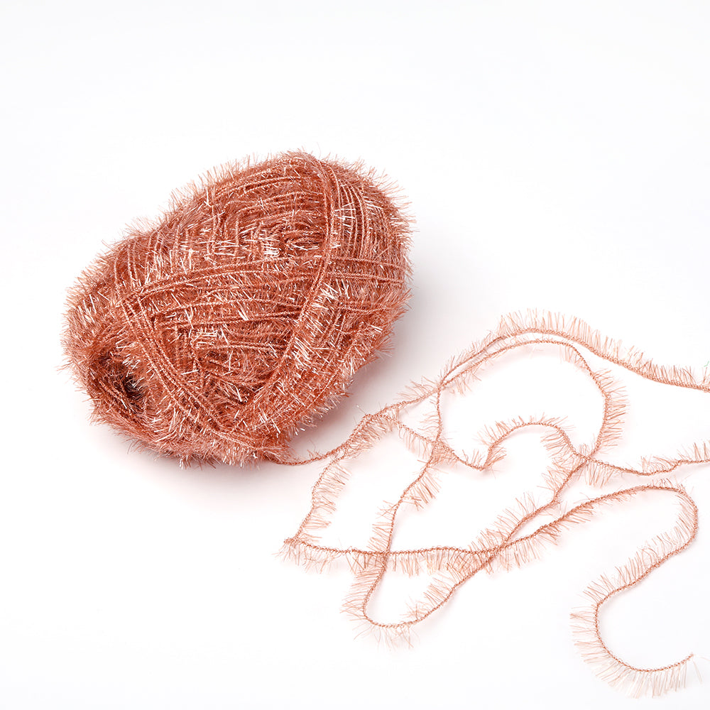 Eine Kugel aus glänzendem, strukturiertem kupferfarbenem Rico Design Creative Bubble Garn mit einem losen Strang sitzt auf einem weißen Hintergrund - perfekt für Spüllappen häkeln oder jedes Projekt, das robustes Garn benötigt.