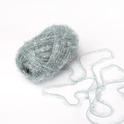 Ein Knäuel hellblaues, flauschiges Rico Design Creative Bubble Garn mit einigen Strängen, die sich auf weißem Grund auflösen - ideal zum Häkeln von Geschirrtüchern oder anderen kreativen Projekten.