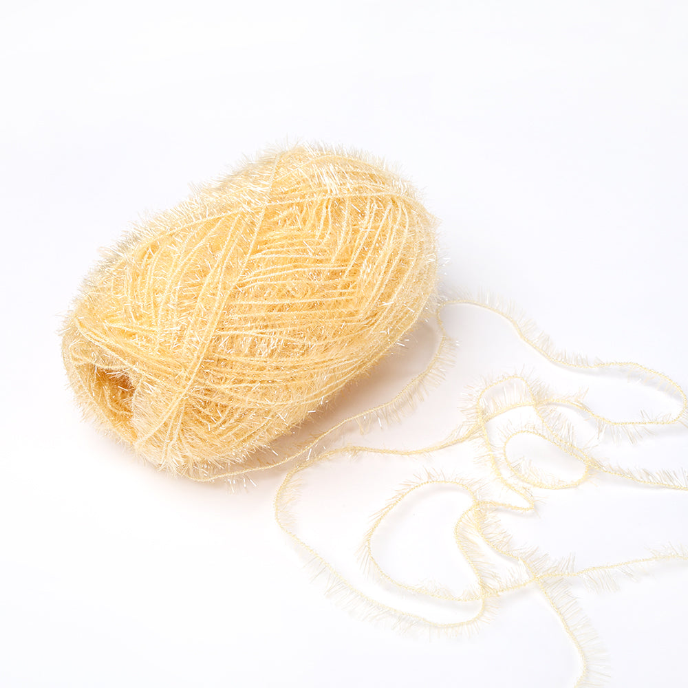 Ein Knäuel hellgelbes, flauschiges Garn von Rico Design, perfekt für Häkelprojekte wie Spüllappen, mit einem losen Strang auf weißem Grund.