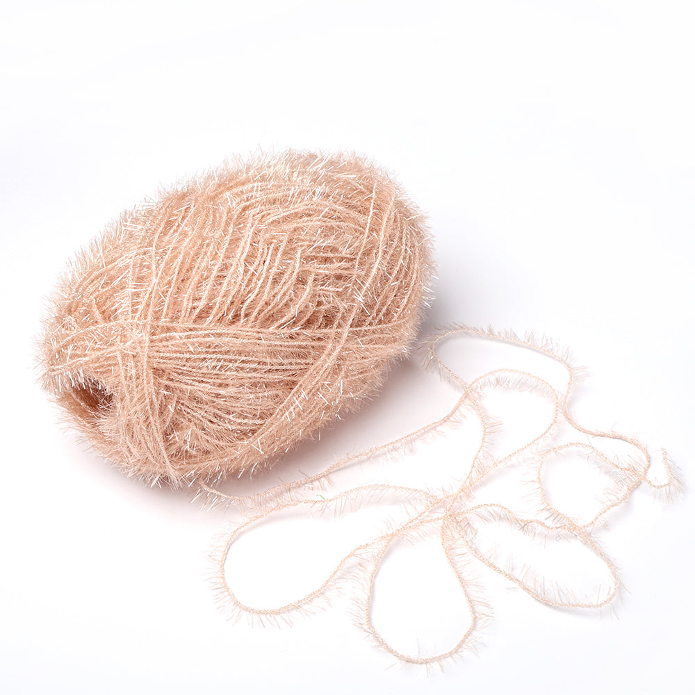 Ein Knäuel hellbeiges, flauschiges Rico Design Creative Bubble Garn mit einem losen Strang auf weißem Grund - perfekt zum Häkeln von Spüllappen oder anderen Projekten, die ein haltbares Garn benötigen.