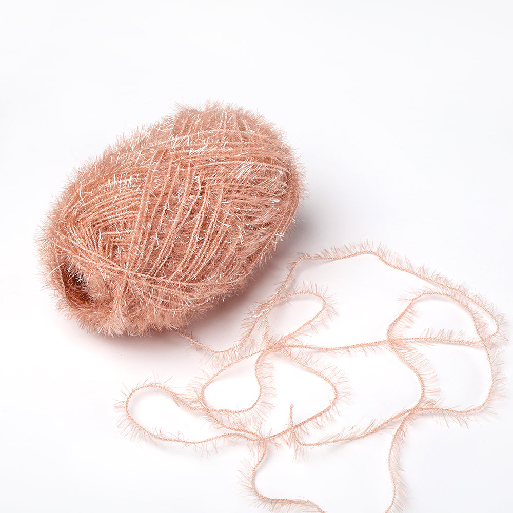 Ein Knäuel aus weichem, flauschigem, hellrosa Rico Design Creative Bubble Garn mit einem losen Faden liegt auf einem weißen Hintergrund - ideal zum Häkeln von bunten Geschirrtüchern.