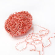 Eine Kugel aus glitzerndem rosa Rico Design Creative Bubble Garn mit einem losen Strang auf weißem Hintergrund - ideal für bunte Spüllappen häkeln oder jedes Projekt, das robustes Häkelgarn benötigt.