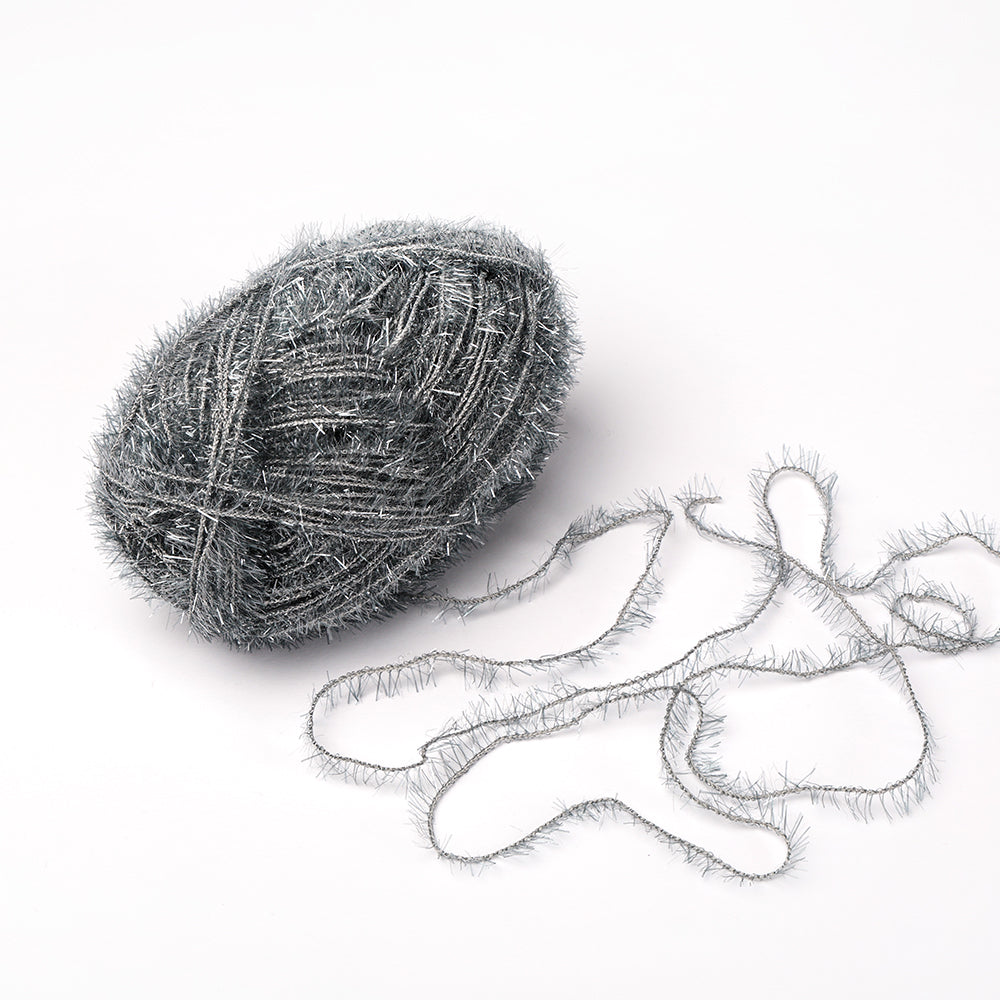 Ein Knäuel Creative Bubble Garn in Metallic-Silber von Rico Design, mit einer flauschigen Struktur und teilweise aufgedreht auf weißem Grund - ideal zum Häkeln von lustigen Geschirrtüchern.