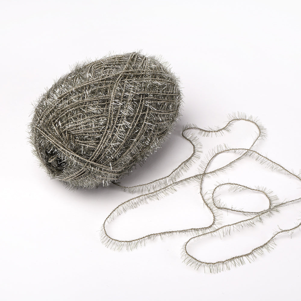 Eine Kugel aus metallisch-silbernem Rico Design Creative Bubble Garn mit flockiger Textur sitzt auf weißem Hintergrund - ideal für Häkeln Spüllappen aufgrund seiner robusten Garnqualitäten.