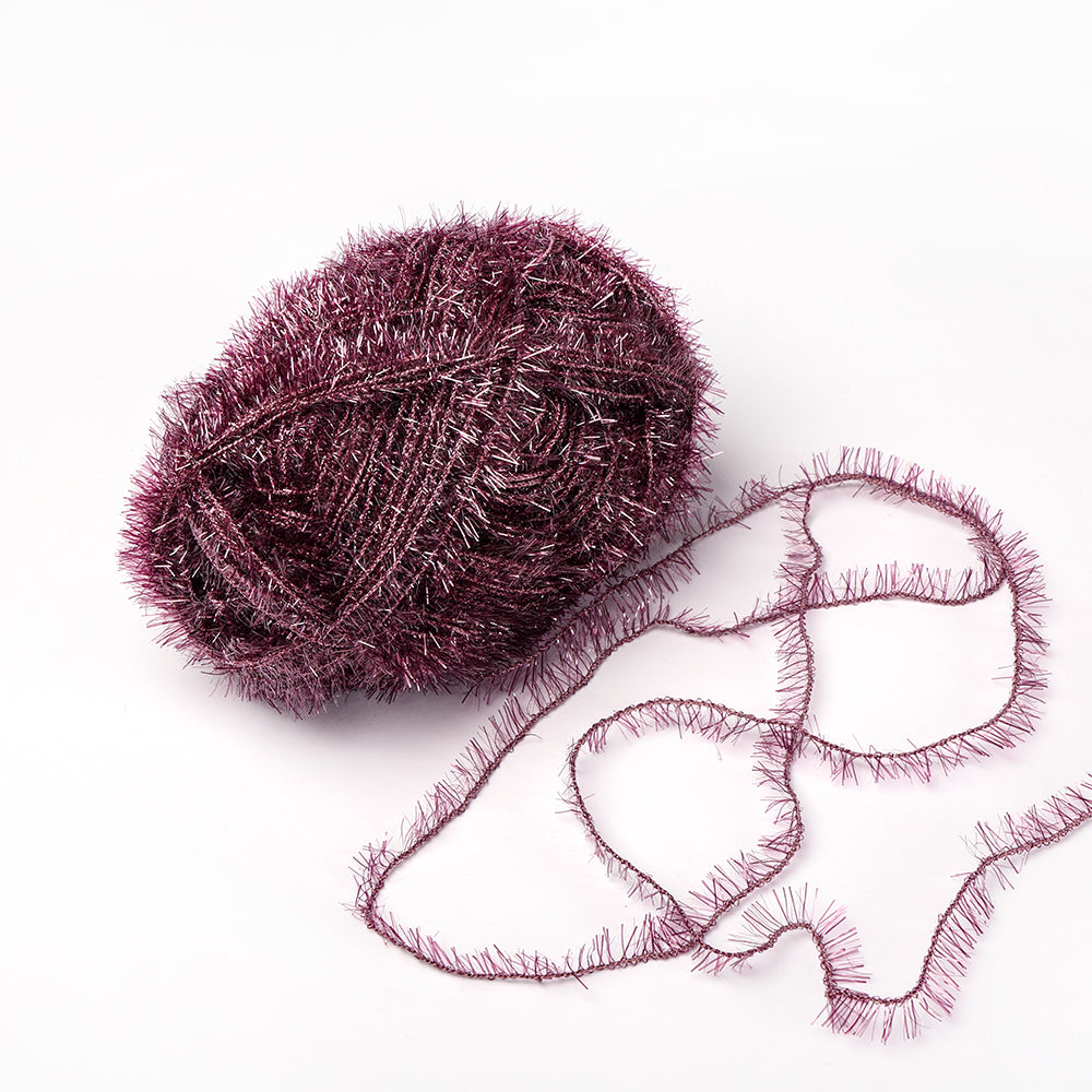 Ein glitzerndes lilafarbenes Rico Design Creative Bubble Garnknäuel mit einem losen Strang auf weißem Grund, ideal für Häkelprojekte wie Spüllappen.