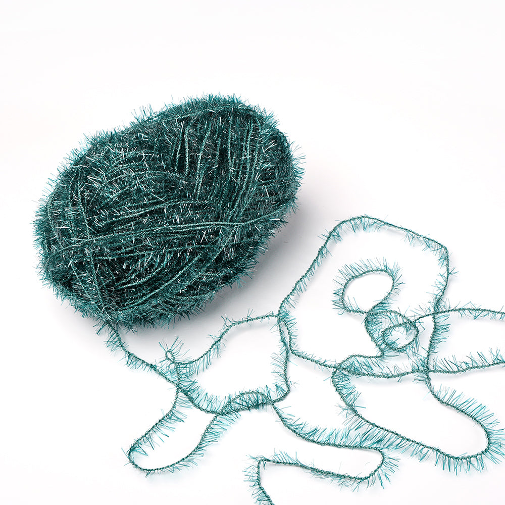 Ein Knäuel grünes Fuzzy-Garn aus dem Creative Bubble Garn von Rico Design mit einer losen Länge, die in Schlingen auf weißem Hintergrund angeordnet ist.