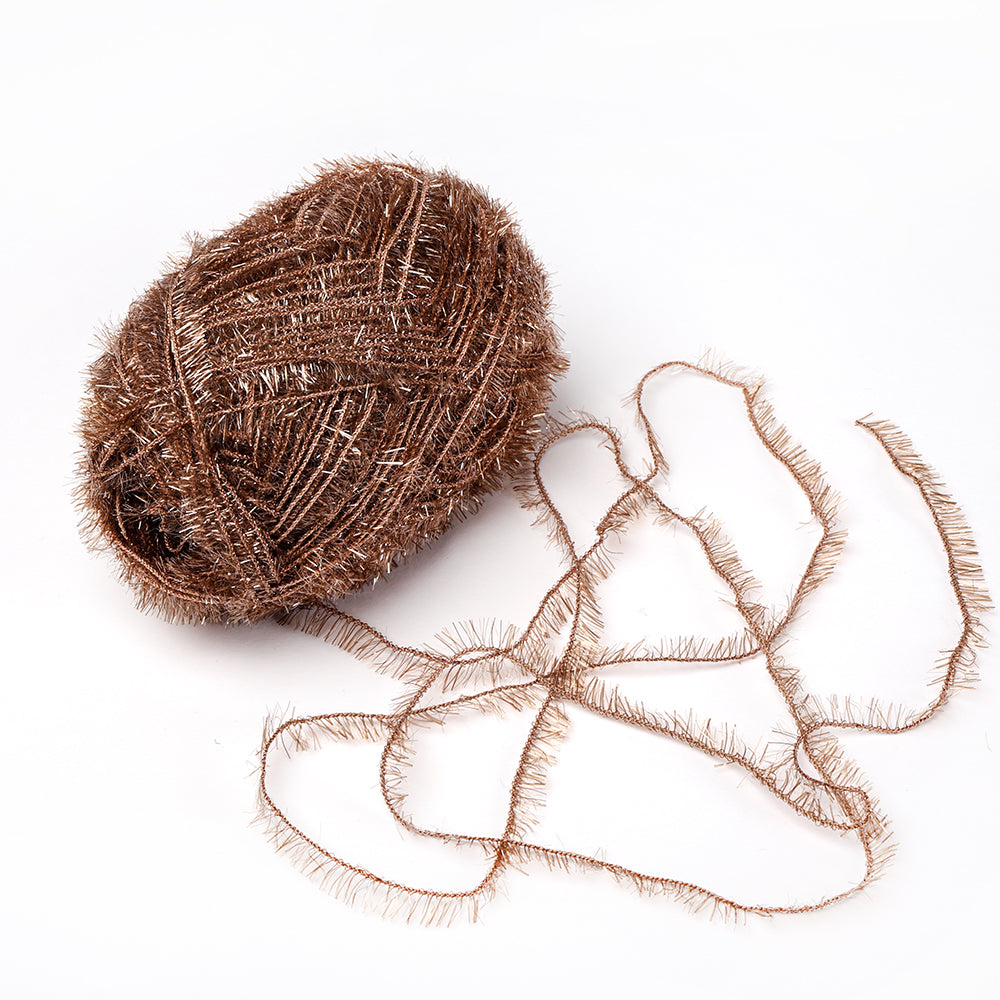 Ein Knäuel metallisch braunes Rico Design Creative Bubble Garn Wimperngarn mit einem losen Strang auf weißem Grund, ideal für Häkelprojekte wie Schwämme oder Geschirrtücher.