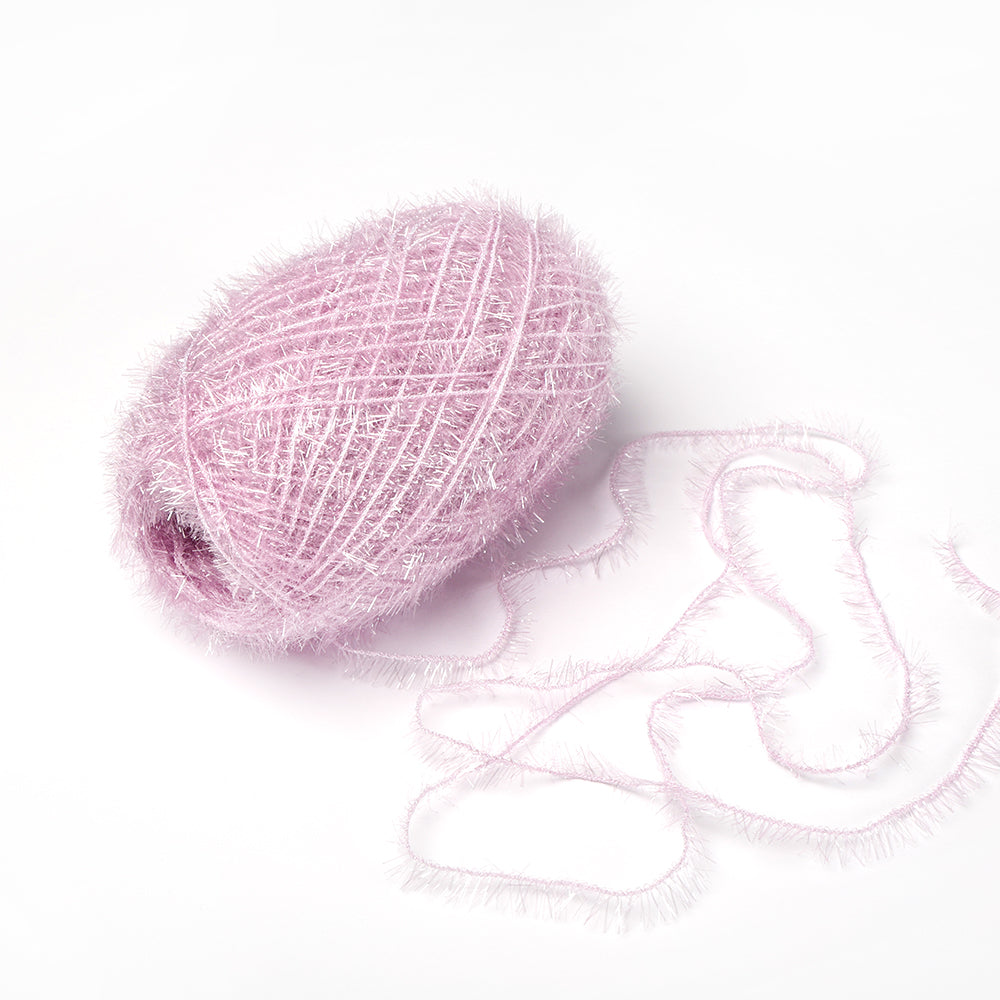 Ein Knäuel des blassrosa, flauschigen Rico Design Creative Bubble Garns mit einem losen Faden ruht auf einem weißen Hintergrund - ideal zum Häkeln von Geschirrtüchern.