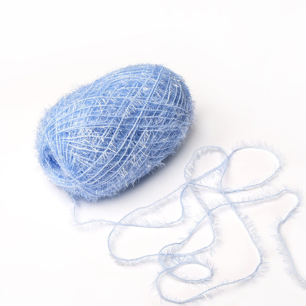 Ein Knäuel hellblaues, flauschiges Rico Design Creative Bubble Garn mit einem losen Strang auf weißem Grund - perfekt zum Häkeln von Geschirrtüchern und anderen Projekten, die strapazierfähiges Garn benötigen.