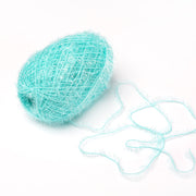 Ein Knäuel hellblaues, flauschiges Rico Design Creative Bubble Garn mit losen Fäden auf weißem Grund - ideal zum Häkeln von robusten Geschirrtüchern.