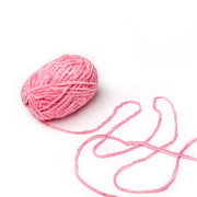 Ein Knäuel Rico Design rosa Chenille-Garn mit einem losen Strang auf weißem Grund, ideal zum Häkeln und Kreieren von superflauschigen Garn-Projekten.
