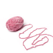 Ein Knäuel aus rosafarbenem Rico Design Häkelgarn mit einer Chenille-Struktur und einem losen Strang liegt auf weißem Hintergrund.