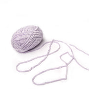 Ein Knäuel aus hellviolettem Rico Design Chenille-Garn mit losen Fäden liegt auf weißem Grund - ideal zum Häkeln von Kuscheltüchern mit speichelechter Farbe.