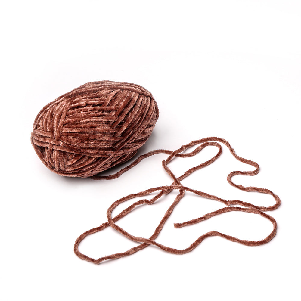 Ein Knäuel aus braunem Rico Design Chenille-Garn mit einem lockeren, gewellten Strang auf weißem Grund - ideal zum Häkeln von Kuscheltüchern oder für kreative Bastelprojekte.