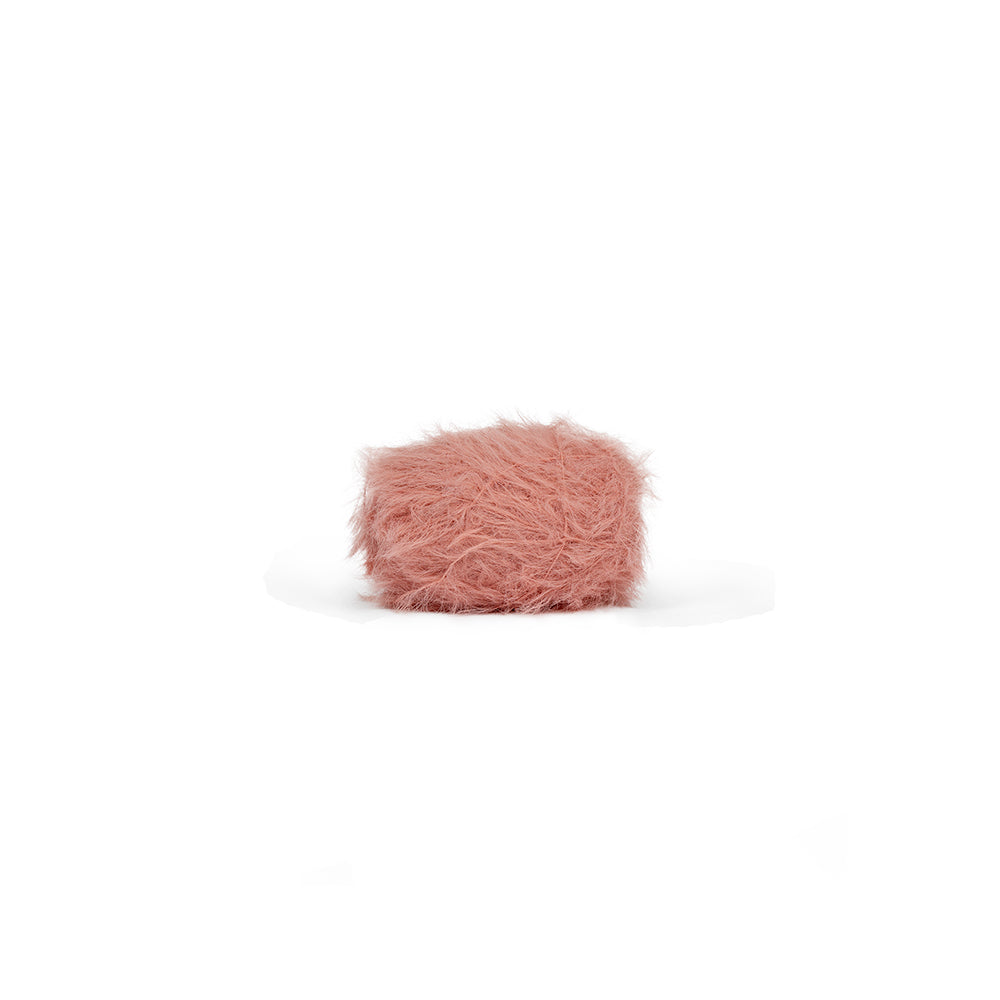 Ein Knäuel staubrosa, flauschiges Garn, das wie Fell aussieht.