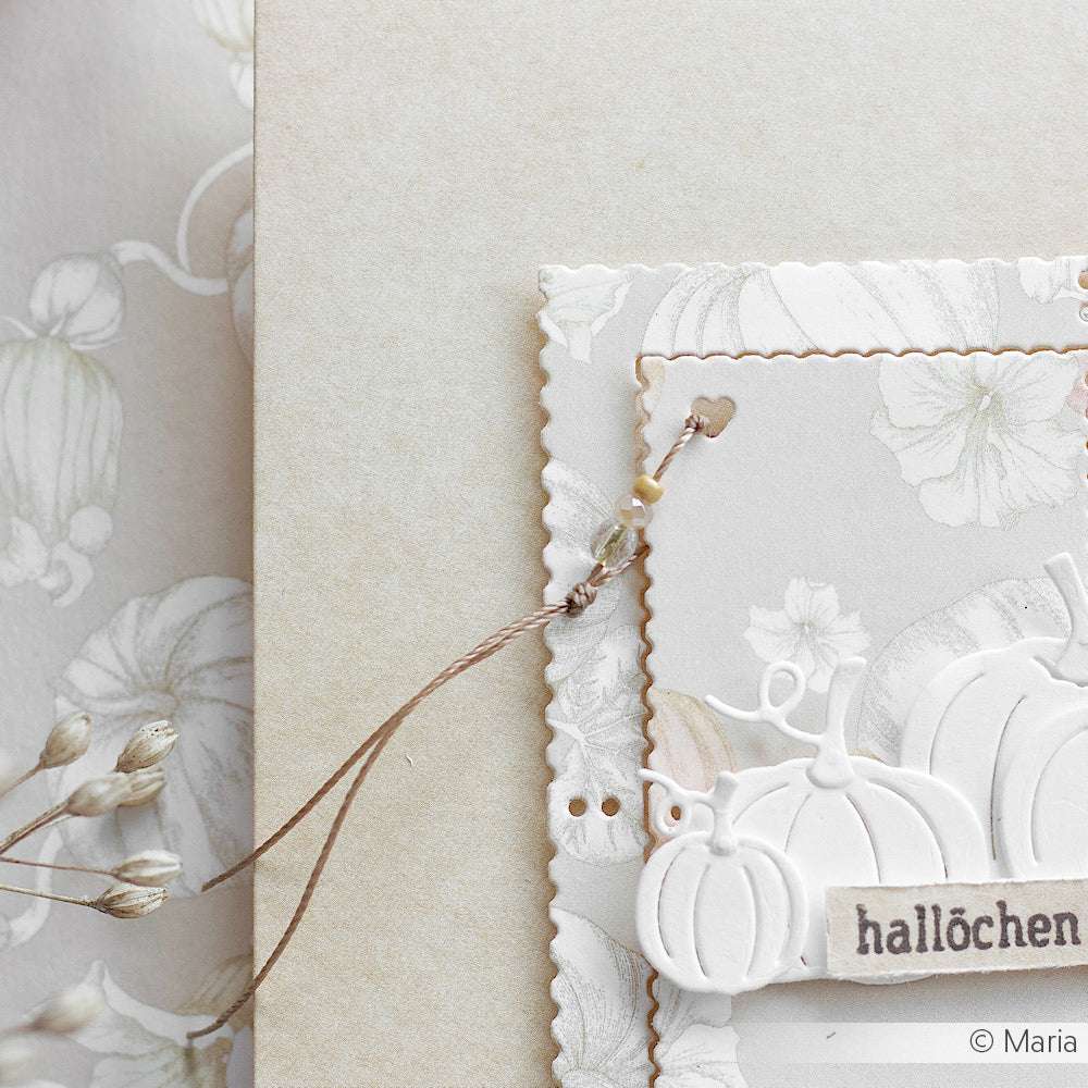 Eine Nahaufnahme einer eleganten, neutral getönten Halloween-Karte von Alexandra Renke mit geprägten Kürbissen und zarten Makramee-Kettenakzenten.