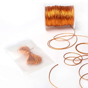 Eine Spule mit glänzender Kupferkordel mit losen Strängen und eine gebündelte Kordel von Alexandra Renke, verpackt in einem durchsichtigen Beutel - perfekt für jedes Bastelprojekt.