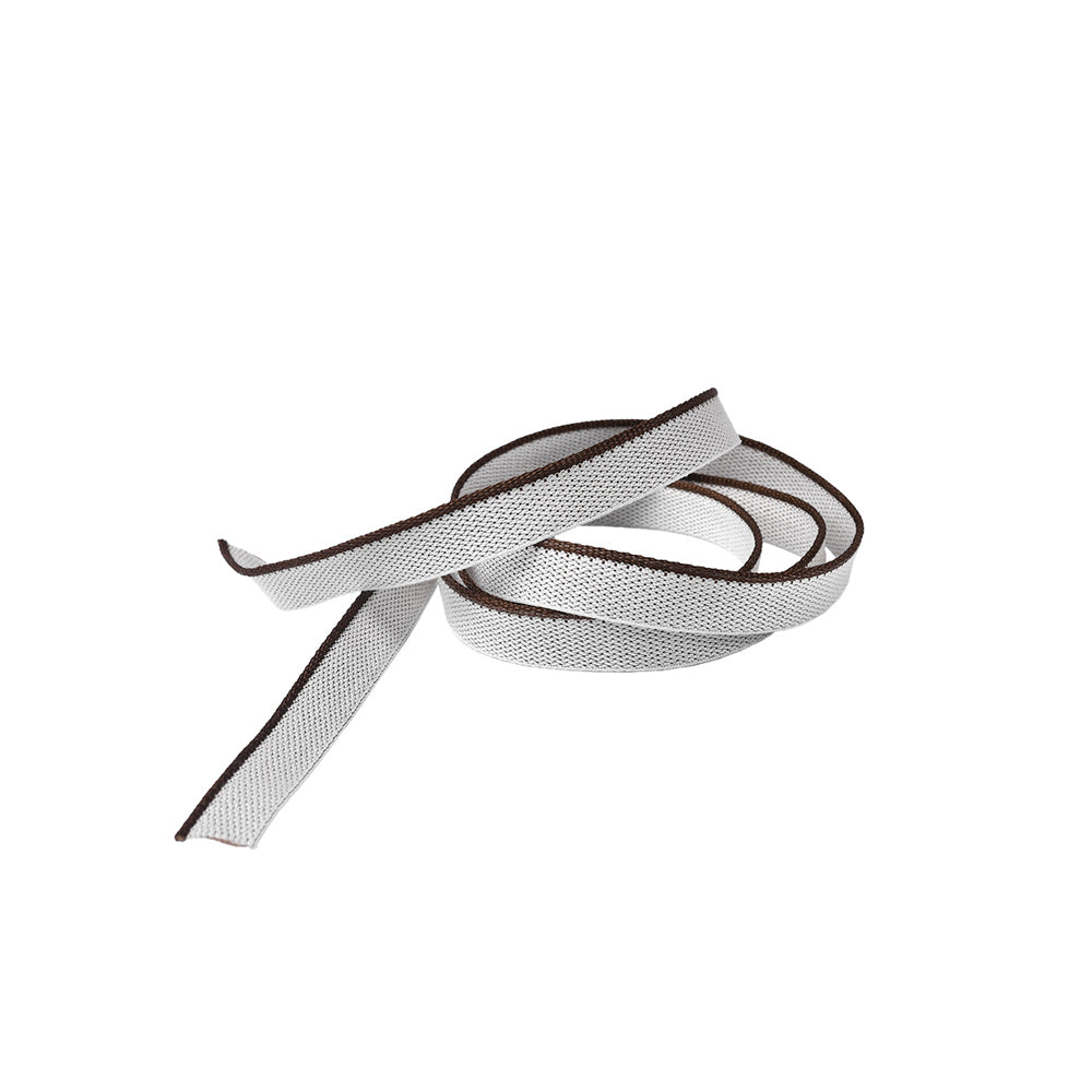 Ein gewundener, flacher weißer Schnürsenkel mit dunkelbraunen Rändern von Alexandra Renke, der an einen Kapitalband in Hardcover-Büchern erinnert, liegt auf weißem Grund.