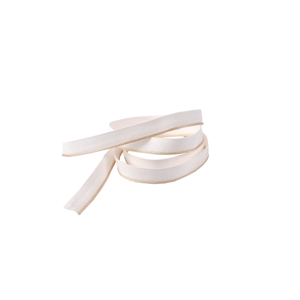 Ein gewundenes, flaches, weißes Stoffband von Alexandra Renke - oft als Kapitalband in Buchrücken von Hardcover-Büchern verwendet - liegt auf weißem Hintergrund.