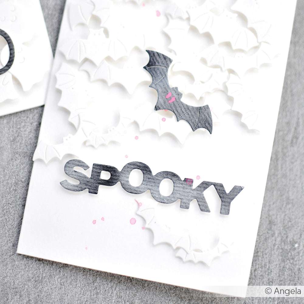 Weiße Karte von Alexandra Renke mit erhabenen weißen Fledermäusen, einer schwarzen Fledermaus und "SPOOKY" - ideal für Stanzen für Papierbasteln oder Ihre DieCut Systeme Sammlung.