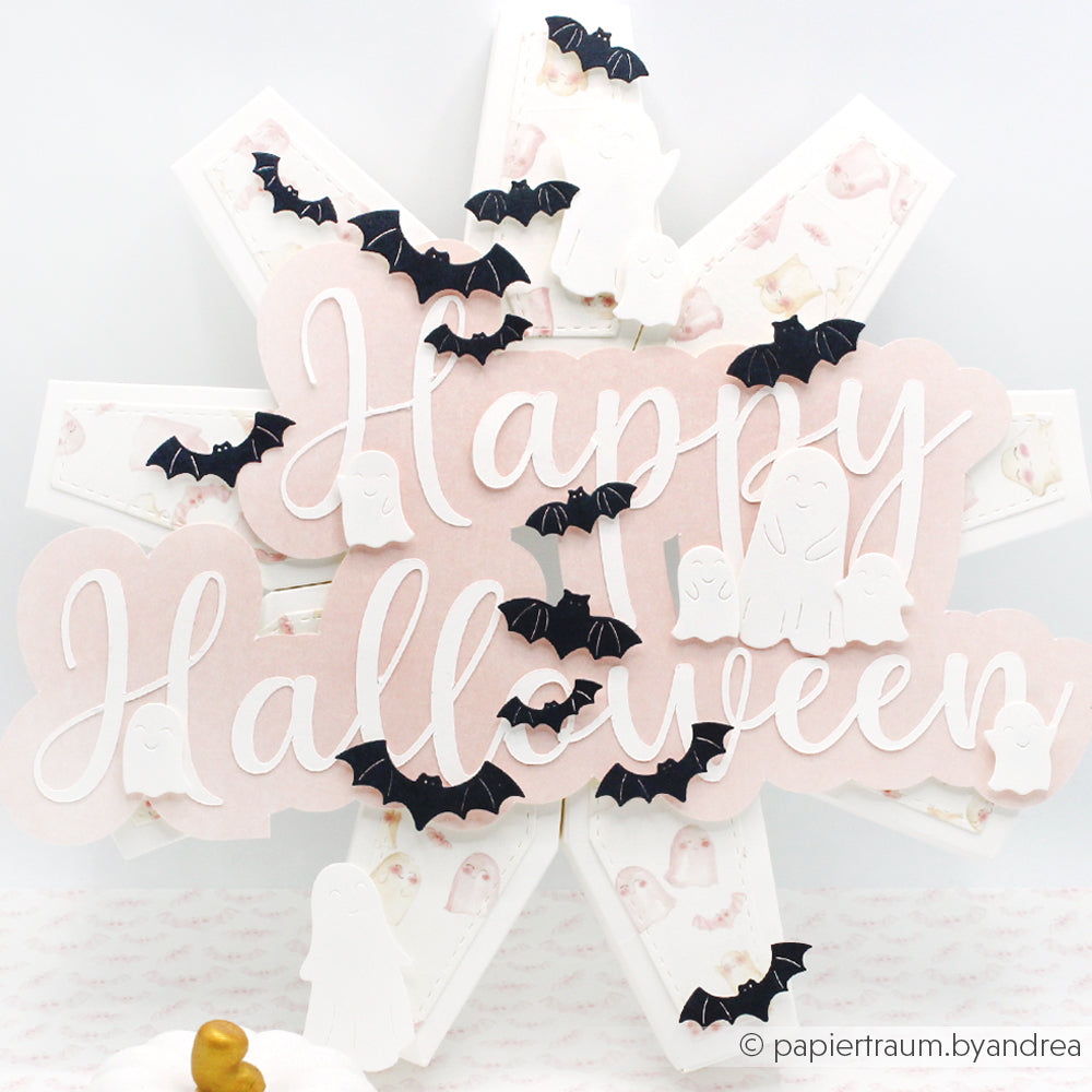 Halloween-Karte mit dem Text "Happy Halloween", schwarzen Fledermäusen, die mit der Alexandra Renke Motivstanze Fledermausschwarm ausgestanzt wurden, und weißen Gespenstern auf sternförmigem Hintergrund - perfekt, um Ihre Projekte mit Alexandra Renke Designpapieren und Stanzsystemen hervorzuheben.
