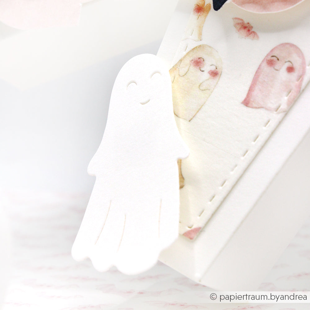 Ein weißer Gespensterausschnitt aus der Alexandra Renke Motivstanze Drei süße Gespenster sitzt neben einer pastellfarbenen Gespensterzeichnung auf einer weißen Karte und zeigt kreative Projekte mit DieCut Systemen und Designpapieren.