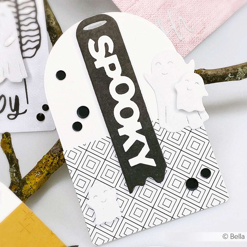 Ein Halloween-Anhänger mit dem fettgedruckten Schriftzug "SPOOKY", mit weißen Geisterformen aus der Alexandra Renke Motivstanze Drei süße Gespenster und kräftigen schwarzen Akzenten - perfekt zum Basteln mit Designpapieren oder Stanzsystemen.