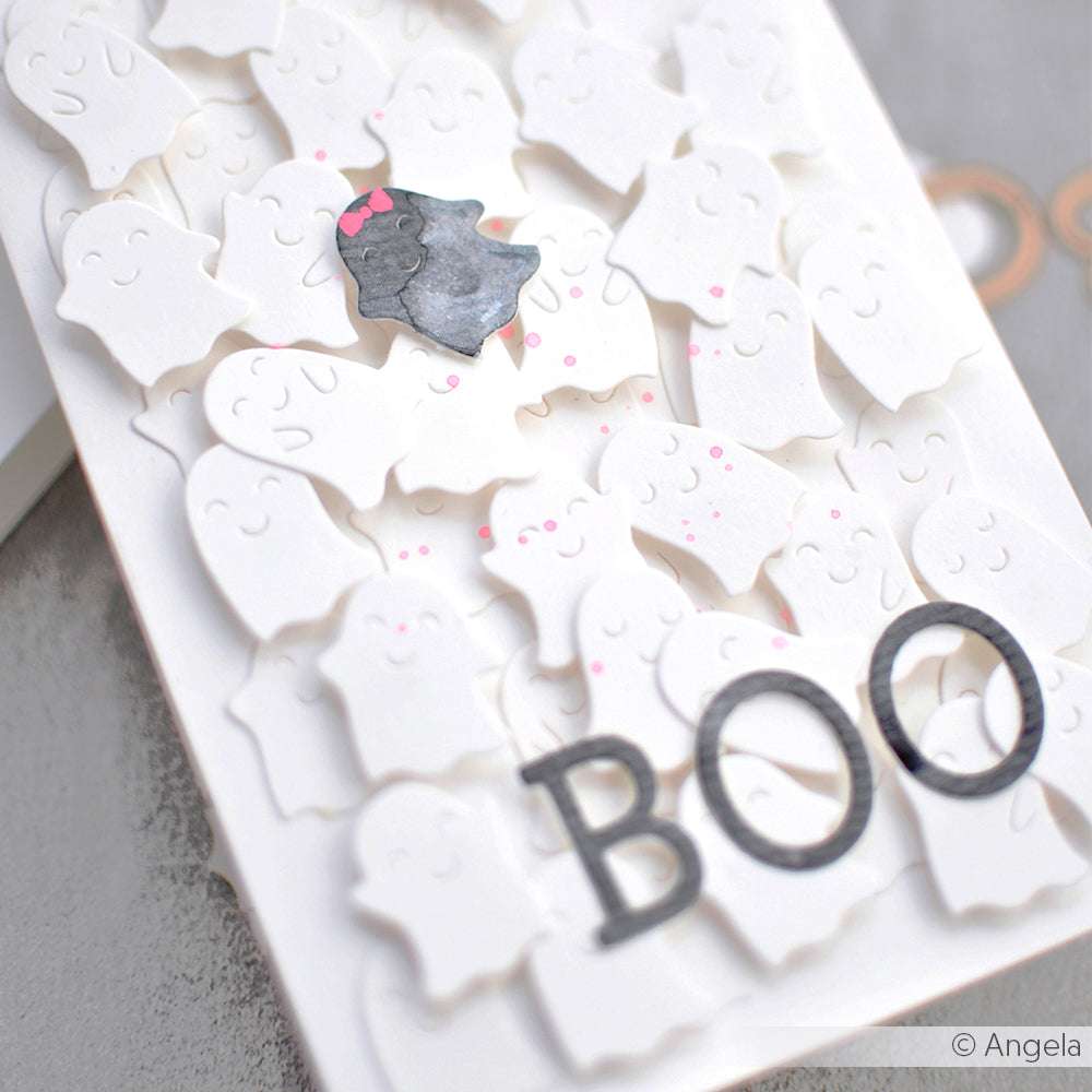 Eine mit Alexandra Renkes Motivstanze Gespenster gestaltete Karte mit weißen Gespensterausschnitten, einem schwarzen Gespenst, rosa Punkten und einem fetten "BOO" auf hochwertigen Designpapieren.