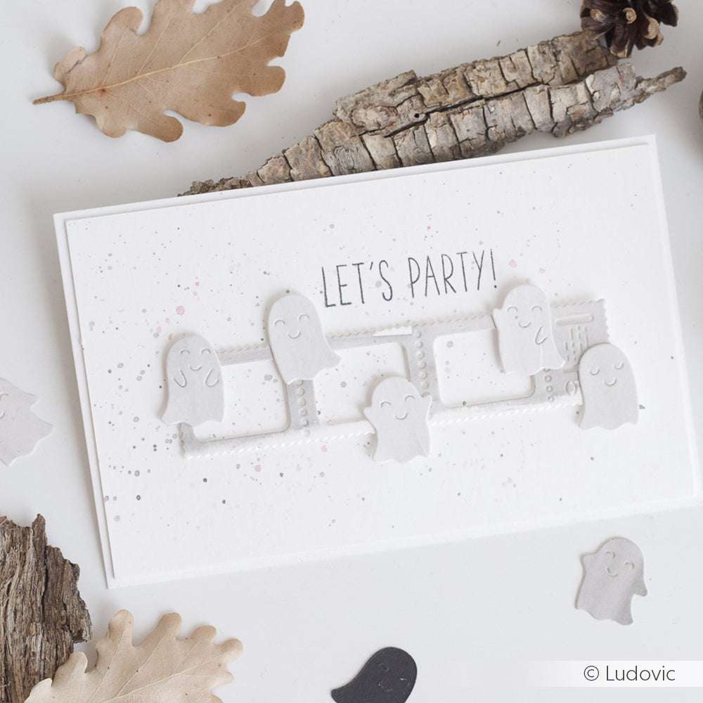 Grußkarte mit lächelnden Geisterausschnitten aus der Alexandra Renke Gespenster Stanze und dem Text "LET'S PARTY!", umgeben von Blättern und Rindenstücken.